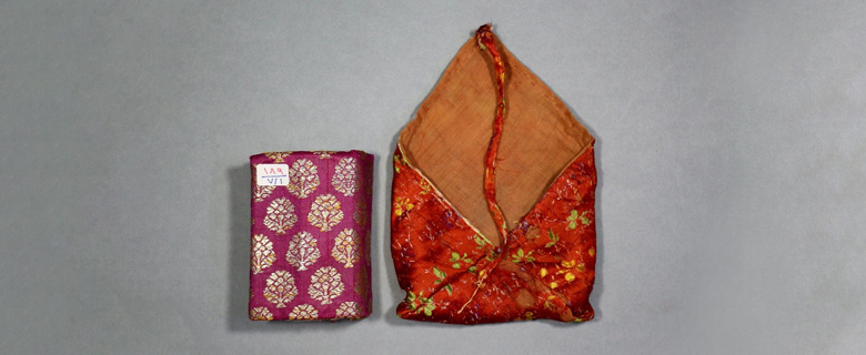 Manuscript bag shown open alongside the enclosed manuscript, illustrating the relationship between the textile enclosure and its contents