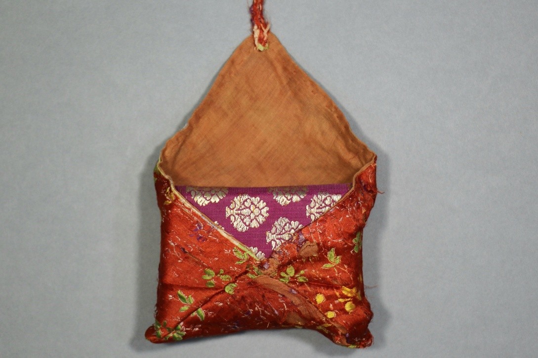 . Manuscript bag shown partially open, revealing the inner lining and the folded textile structure used to enclose and protect the manuscript